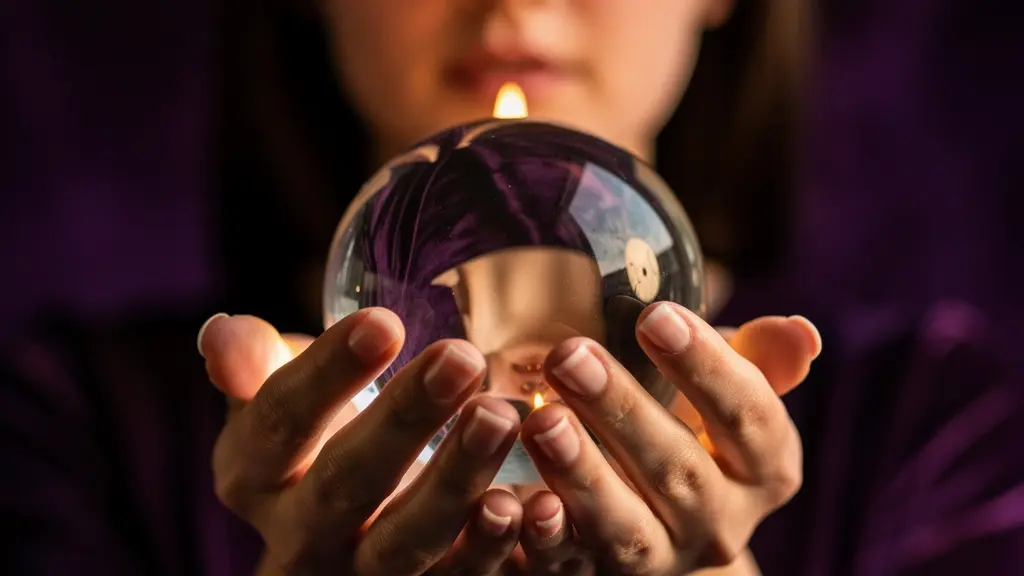 Mani che tengono delicatamente una sfera di cristallo con riflessi sfocati