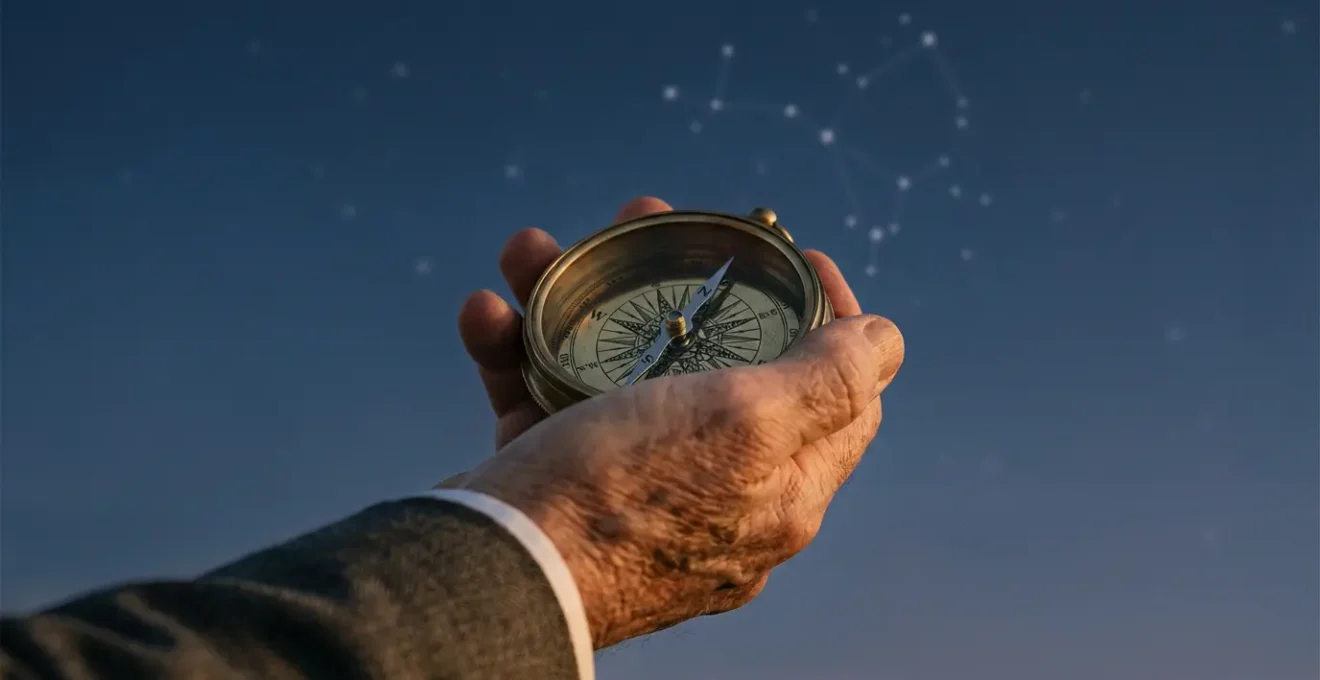 Mano tiene una bussola antica sotto un cielo stellato, simbolo della guida astrologica nelle decisioni